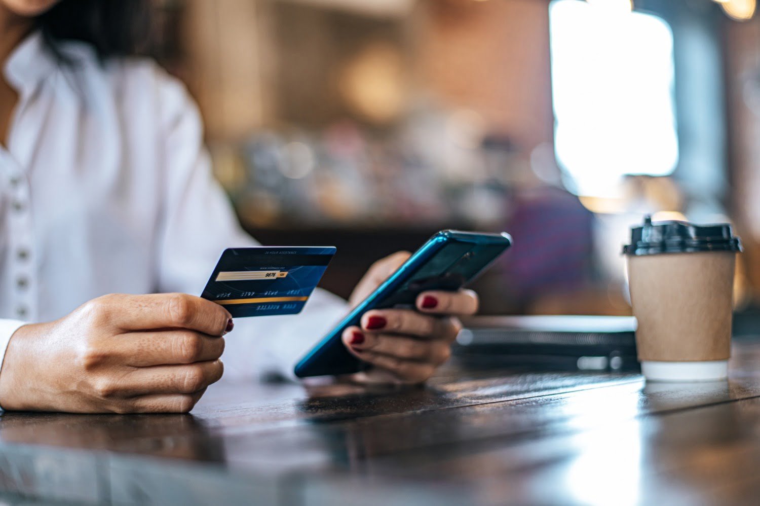 A woman making an online payment using her phone and card, ensuring secure bookings for Reliable & Trusted Drivers service.